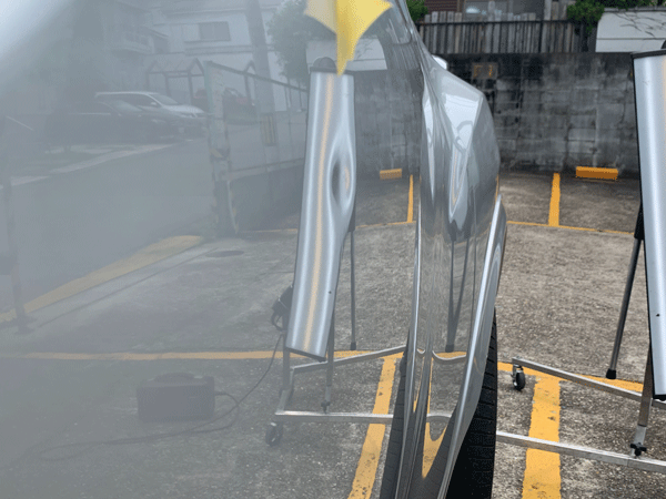 車のボディに近づけて透かした状態。凹みがよりくっきりみえる。